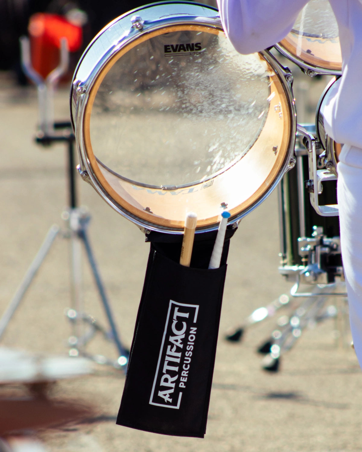 Evans head and Artifact Percussion bag and sticks on a quad drum background